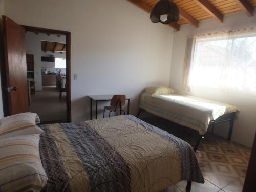 塔巴贝拉Quito Eco Lodge Airport - B&B的一间卧室设有两张床、一张桌子和一个窗口