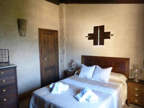 拉伊鲁埃拉Casa Rural Castillo LA Iruela的卧室配有一张床,墙上有十字架