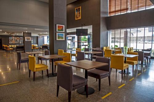 坤敬Le cassia Hotel的用餐室配有桌子和黄色椅子