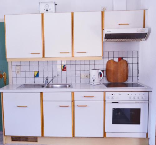 Forchach桑尼汉度假屋的厨房配有白色橱柜和水槽