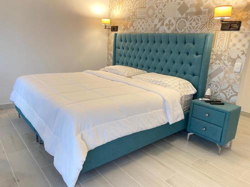 福尔图纳Hotel Arenal Vista Lodge的一间卧室配有一张大床和蓝色床头板