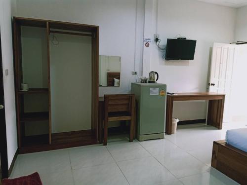 攀牙Rachawadee House的客厅配有绿色冰箱和桌子