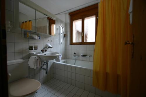 马洛亚波斯特利酒店的浴室配有盥洗盆、卫生间和浴缸。