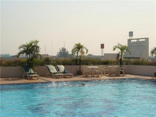 坤敬祡润芳尼孔敬酒店的一个带椅子和桌子的游泳池,并种植了棕榈树