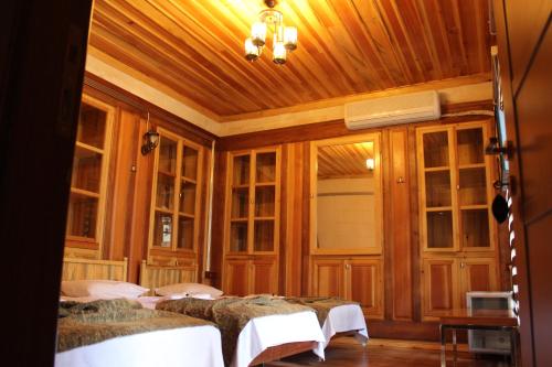 ŞahinbeyDuran Aga Konagi的一间带四张床的卧室,位于带木墙的房间内