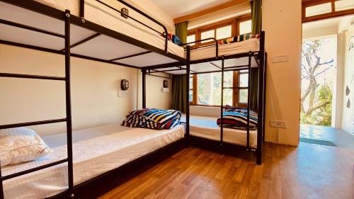 马拉里Madpackers Manali的客房设有两张双层床和一扇窗户。