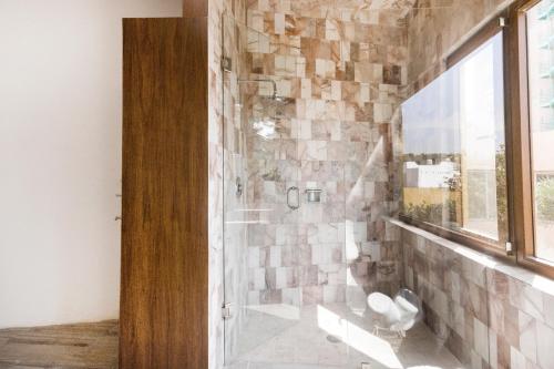 圣路易斯波托西Azabu Hotel Collection的带淋浴的浴室(带石墙)