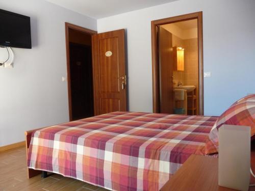 圣克兹索佐帕特里齐亚别墅酒店的一间卧室配有一张带铺着平底毯的床