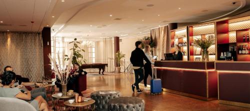 斯德哥尔摩Hotel Hasselbacken的酒店大堂有手提箱的男人