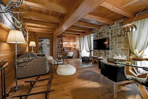 利莫内皮埃蒙特Fiocco di Neve Relais & SPA的客厅设有木制天花板和石墙
