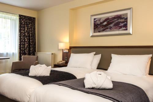 诺里奇诺威奇北假日酒店的酒店客房,配有两张床和椅子