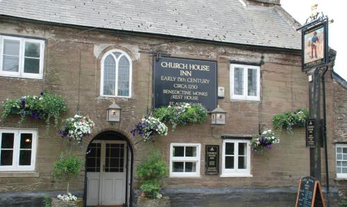 金斯布里奇Church House Inn, Churchstow的一座旧砖砌的建筑,上面有标志