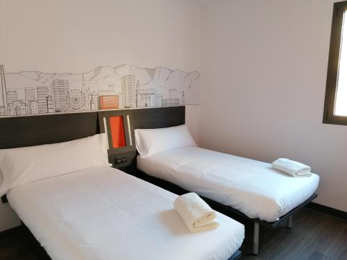 马拉加easyHotel Malaga City Centre的墙上壁画的房间里设有两张床
