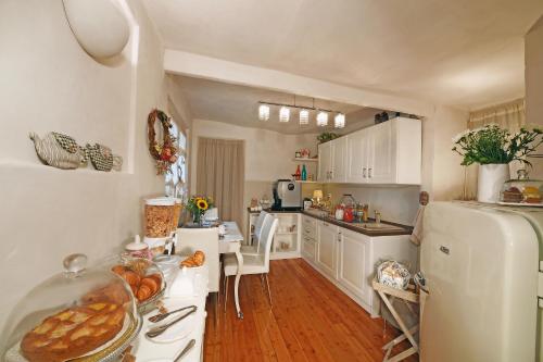 蒙多维圣阿戈斯蒂诺住宿加早餐旅馆的厨房配有白色橱柜和白色冰箱。