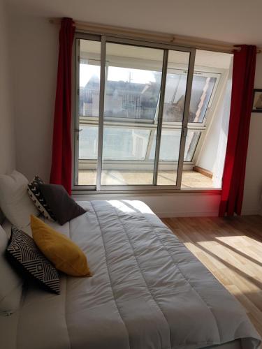 乌伊斯特勒昂studio front de mer的一张大床,位于带大窗户的房间里