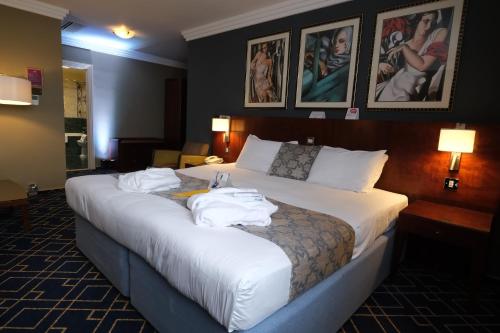 利物浦皇冠假日利物浦约翰·列侬机场酒店&度假村的酒店客房,配有带毛巾的床