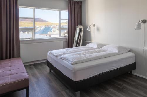 韦斯特曼纳埃亚尔哈马尔旅馆的一间卧室设有一张床和一个大窗户
