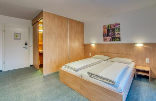 霍恩埃姆斯霍恩埃姆斯汽车旅馆的一间卧室配有一张大床和木制床头板