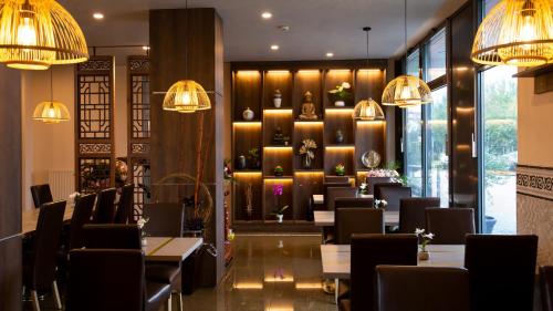 布拉格萨帕酒店的用餐室配有桌椅和吊灯。