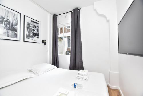 巴黎CMG Résidence Bonne Nouvelle / Fbg Poissonnière的卧室配有白色的床和电视