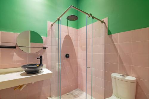 卡塔赫纳CASA MOVIDA HOSTEL的浴室设有玻璃淋浴间、水槽和卫生间