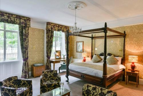 埃文河畔斯特拉特福查理柯德费仁特酒店的一间卧室配有一张天蓬床和两把椅子