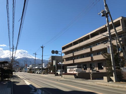 富士河口湖SAWA酒店的一条空荡荡的街道,有一座建筑和一座山