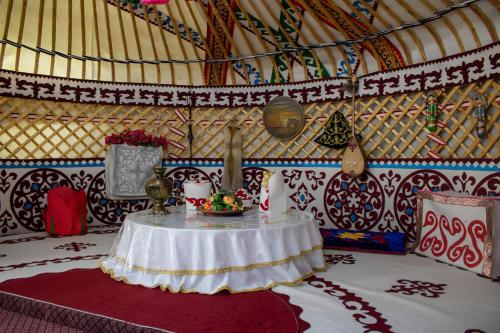 塔拉兹Hotel Zhambyl的蒙古包内带桌子的房间
