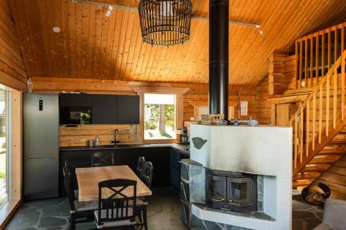 MuurameKalaranta Cottage的小木屋内的厨房和带壁炉的用餐室
