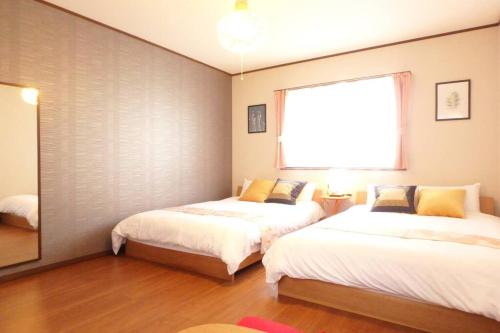 京都Fukenouchi House的一间卧室设有两张床和窗户。