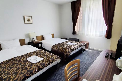 立川市立川丽晶酒店的酒店客房,配有两张床和椅子