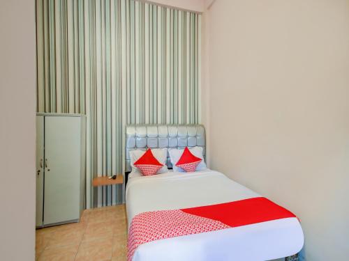 TebingtinggiSUPER OYO 3389 Sonya Homestay Syariah的一间卧室配有红色和白色枕头的床