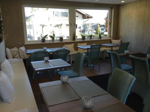 巴特维塞玛格丽特酒店的餐厅设有桌椅和窗户。