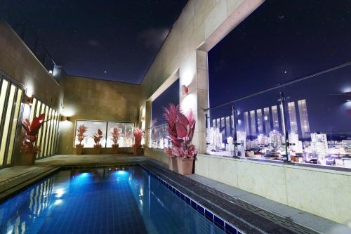 蔚山Ashton Hotel的一座城市建筑中的游泳池