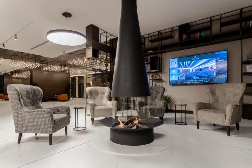 布尔加斯Hotel Bulgaria的客厅设有壁炉、椅子和电视