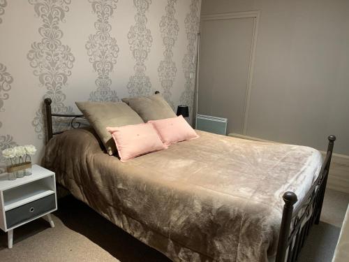 克卢尼La Maison Clémenso的一间卧室配有一张带两个粉红色枕头的床