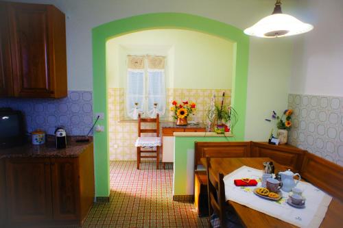 圣米尼亚托Casa Fonte di Bacco的一间带绿色墙壁和桌子的厨房以及一间用餐室