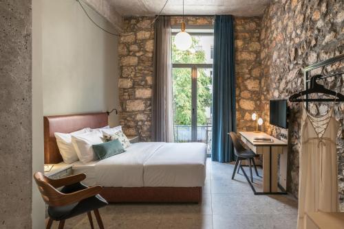 雅典Cohort Koukaki的一间卧室配有一张床、一张书桌和一个窗户。