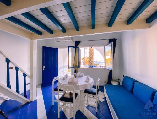 莫纳斯提尔Marina Cap Monastir- Appart'Hôtel的蓝色和白色的客厅配有桌椅