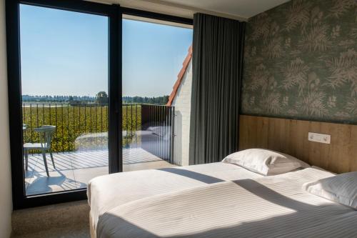 克诺克－海斯特Hotel De Zes Bochten的一间卧室设有一张床,享有阳台的景色