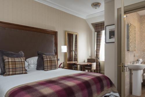 阿维莫尔烟水晶酒店的一间卧室配有一张大床和一张铺着条纹毯子