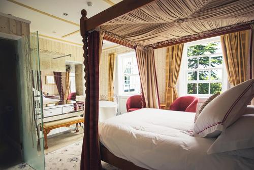 根斯堡希克曼山酒店的一间卧室配有一张天蓬床和一张书桌