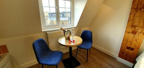 伦敦Angel Townhouse的一个小桌子和两张蓝色椅子在房间里