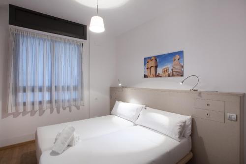 巴塞罗那卡萨科迪纳酒店的卧室配有白色的床铺和白色的枕头