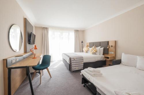 法恩伯勒假日法恩堡酒店的酒店客房配有两张床和一张书桌