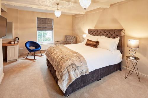 赫里福德The New Inn的一间卧室配有一张大床和一张蓝色椅子