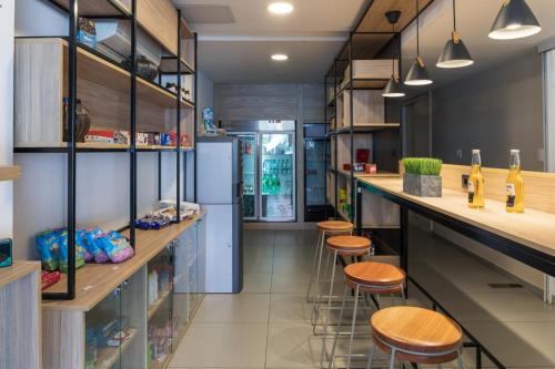 蒙得维的亚南共大学公寓式酒店的厨房配有吧台凳和冰箱。