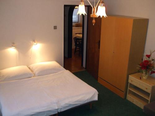 斯塔拉·里斯拉Rekreacny dom Altwaldorf Vysoke Tatry的一间带白色床的卧室和一间带桌子的房间