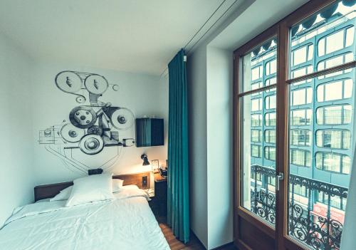 日内瓦日内瓦伯尔尼纳酒店的一间卧室设有一张床和一个大窗户