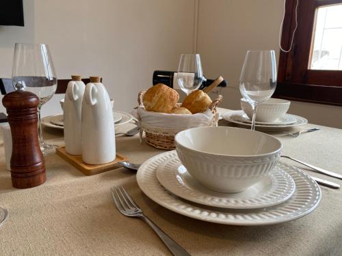杜拉斯诺Apartamento Completo en el centro de Durazno的碗、盘子和酒杯的桌子
